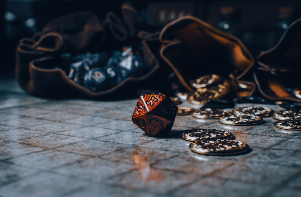 Close-up of a metallic dice with intricate designs on a textured surface.
